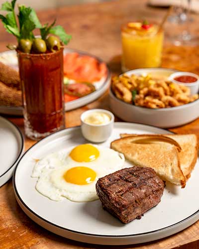 Steak & Eggs, Bloody Mary, Fried Calamari and our Bagel & Lox platter at Extra Virgin Bistro.